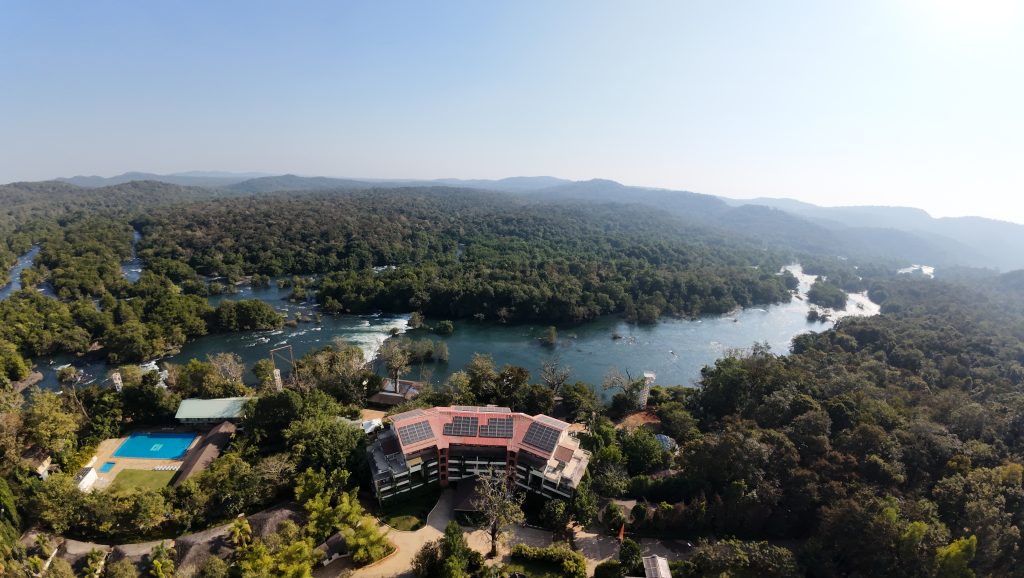 Aerial view of the best resorts in Dandeli nestled amidst dense forest and the flowing Kali River, offering stunning natural beauty and luxurious riverside accommodation | Whsitling Woodzs